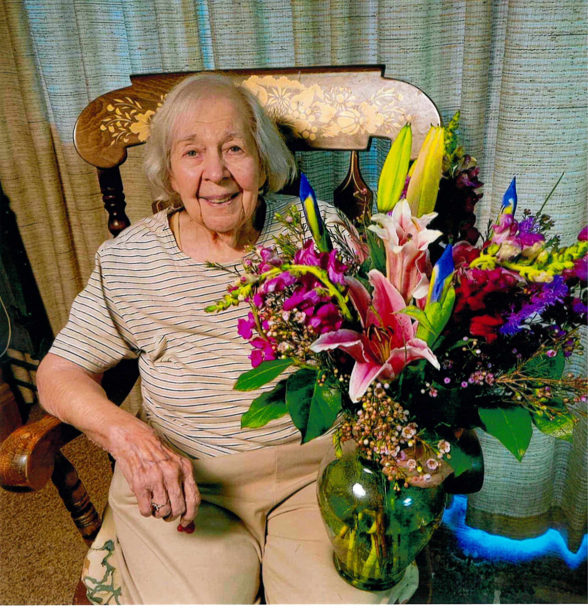 Betty Derick, 97, with a vase of flowers given to her on her birthday