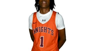 Young woman in orange-on-white basketball uniform with Knights and No. 1 on the jersey front
