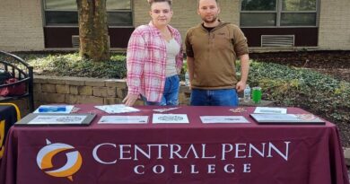 woman and man at a table with Central Penn College Business Club on a banner table cloth