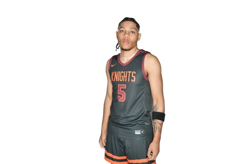 Young man black basketball uniform with Knights and number 5 on jersey front in orange, outlined in white