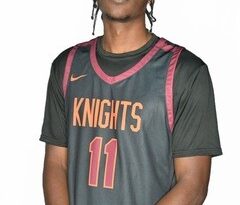 Young man in orange-on-black basketball uniform with Knights and 11 on the front in white-trimmed orange.