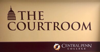 Maroon-on-tan logo-sign of the Central Penn campus courtroom, with The Courtroom and Central Penn College on it