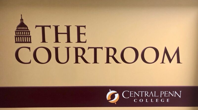 Maroon-on-tan logo-sign of the Central Penn campus courtroom, with The Courtroom and Central Penn College on it