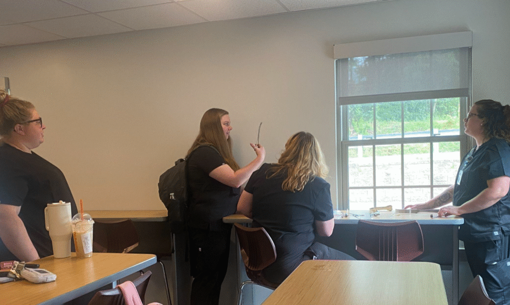 Four women surgical technology students at Central Penn College, in the Surgical Technology Center, practicing use of surgical instruments.