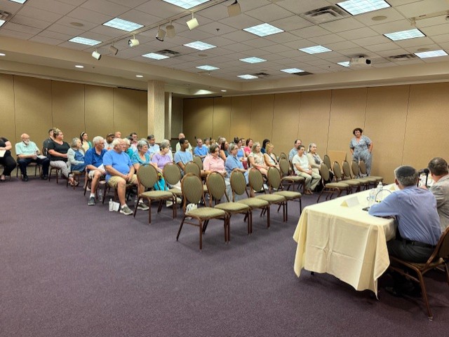 Long shot of about 40 people sitting in chairs in the balroom of the Central Penn College Conference Center and facing a table of panelists for the summer-term Knights of the Roundtable discussion.