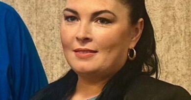 Woman with pinned-back long black hair and wearing a black blazer and gray blouse. Rosanna Wakley.
