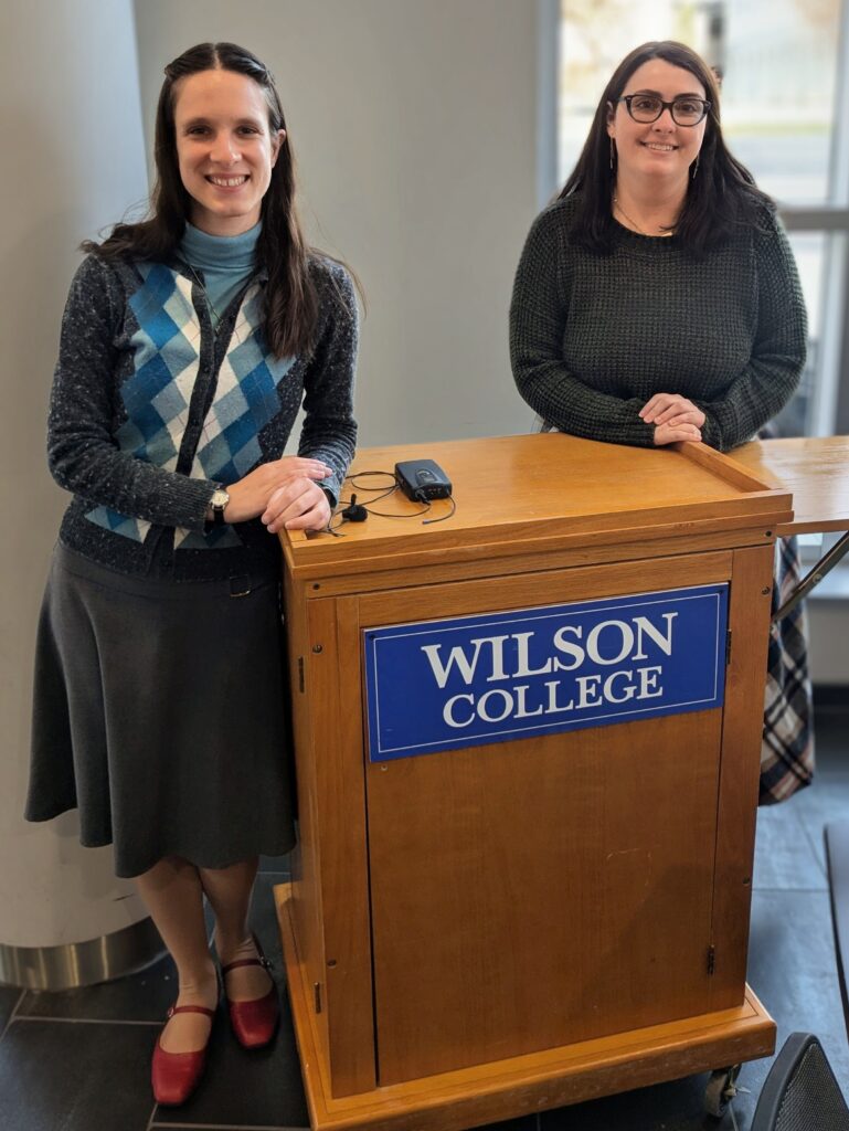 Margaret Schachte, left, Central Penn College's library director, with Cassandra Dwyer, library director of Thaddeus Stevens College of Technology, at a podium with the Wilson College sign on the front.