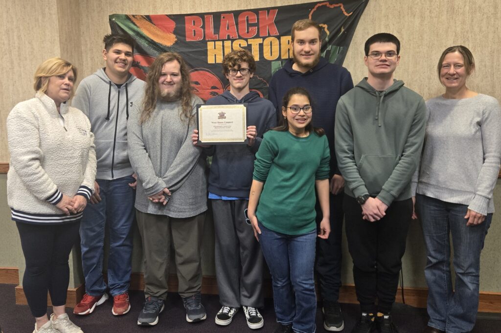 Group of people standing together, West Shore Connect Program students in the middle and a woman teacher on each side.