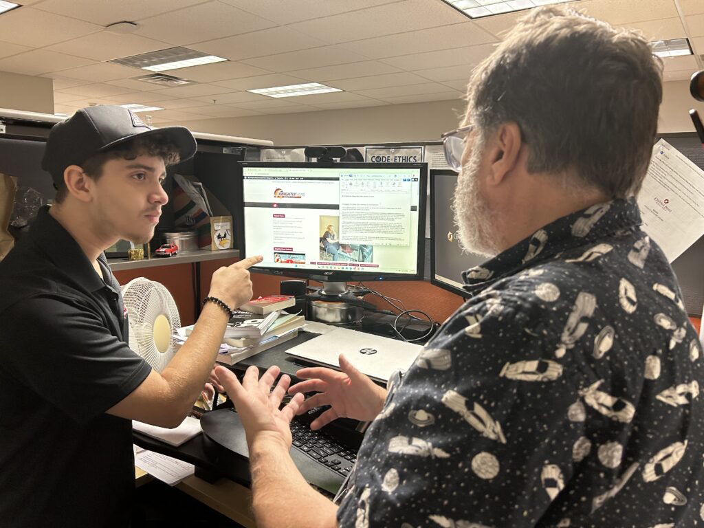 Noah Lopez and Professor Michael Lear-Olimpi working on the 10-anniversary of The Knightly News story in August 2025, at Professor Lear-Olimpi's desk.