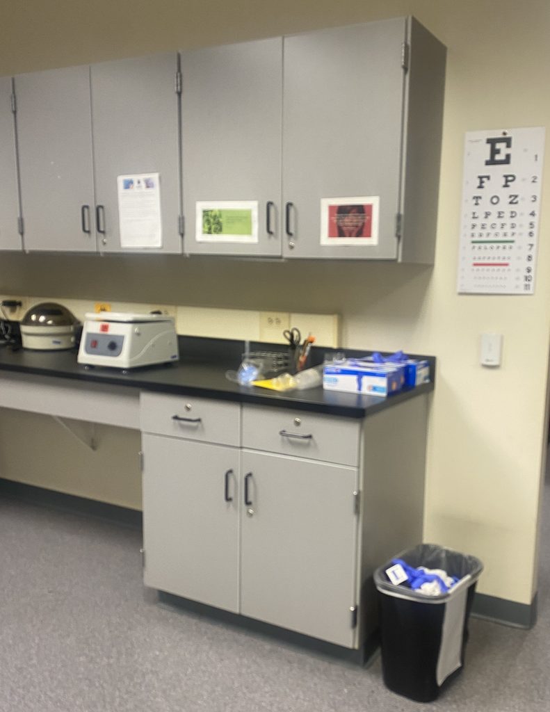 Centrifuges--at left--on a counter, with supplies, and an eye-test chart, in the Central  Penn medical-assisting lab. Photo by Jules Quare