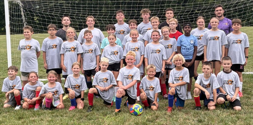 Youth soccer team on a field and in front of a soccer goal. Harrisburg Heat youth summer camp